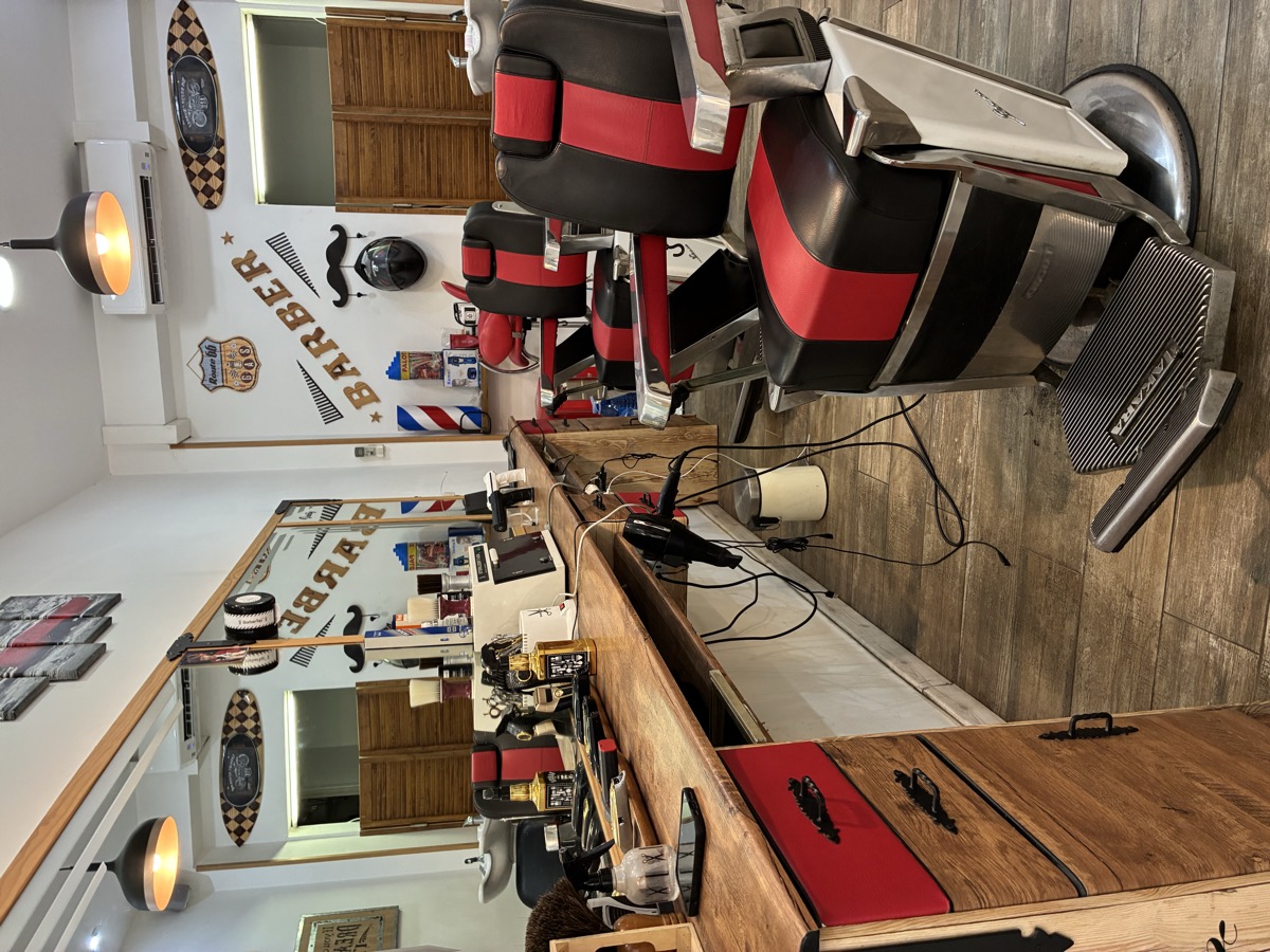 Sillas de barbero clásicas y mostrador de madera barbería The Barber House Barcelona